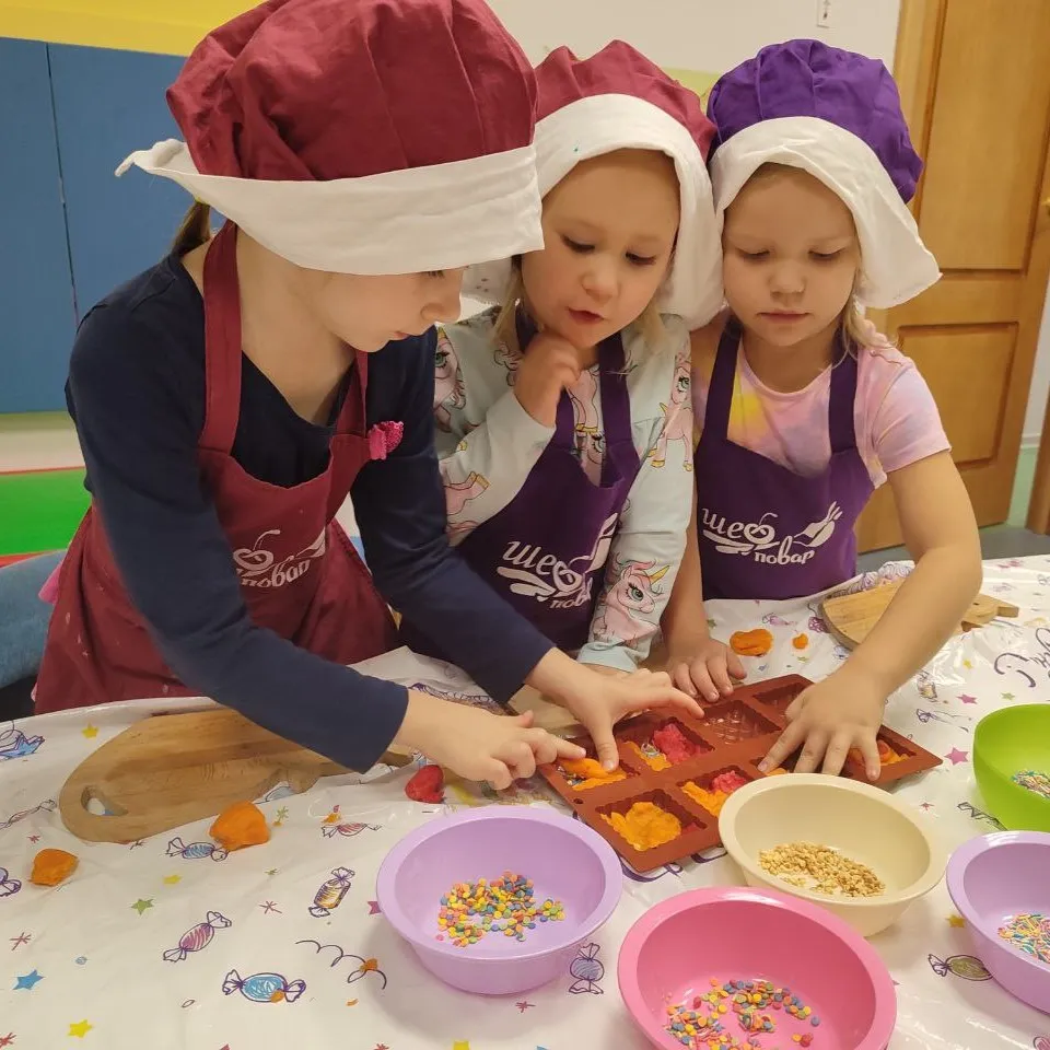 Дети в поварских колпаках на кулинарном занятии